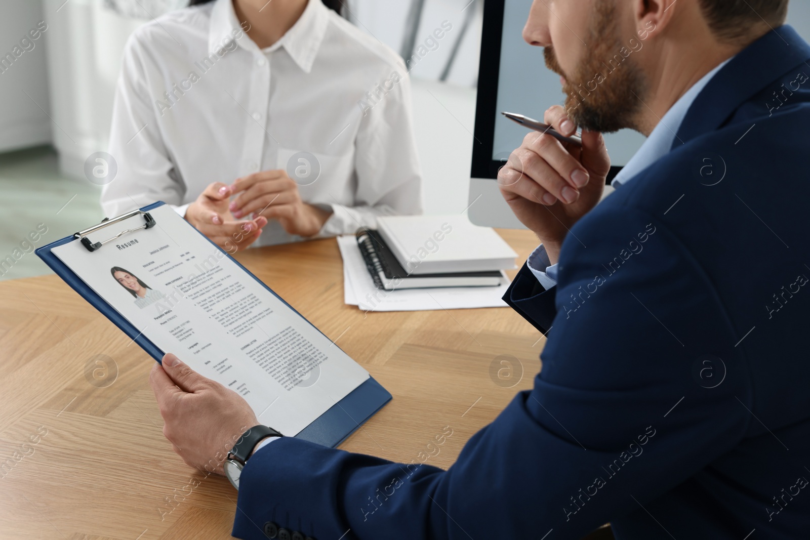 Photo of Human resources manager reading applicant's resume in office, closeup