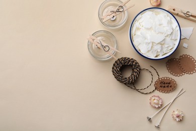 Flat lay composition with homemade candles ingredients on beige background, space for text