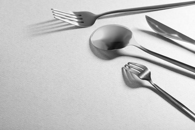 Photo of Forks, knife and spoon on grey background, space for text. Stylish cutlery set