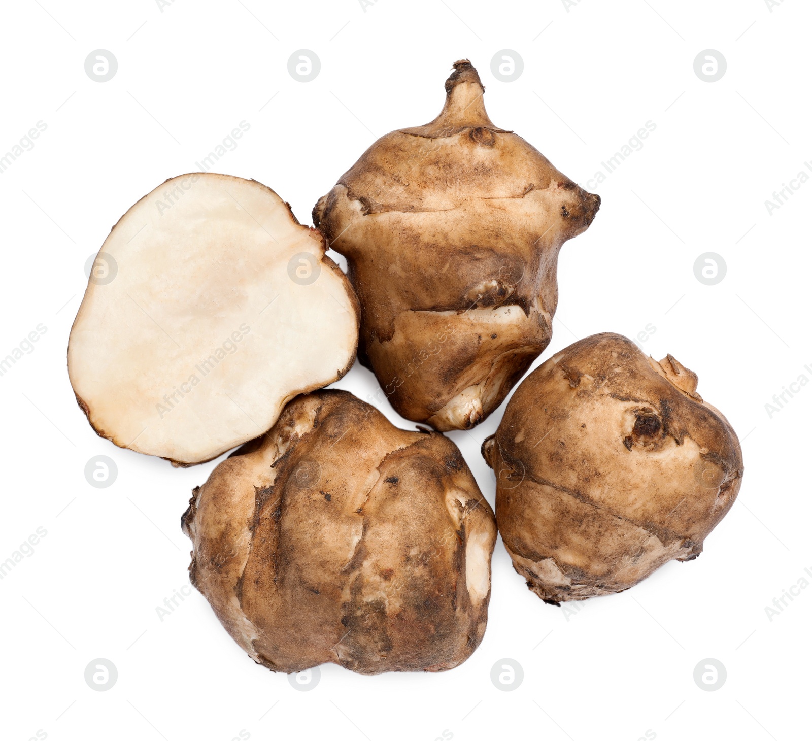 Photo of Whole and cut Jerusalem artichokes isolated on white, top view