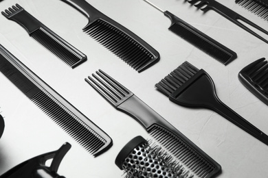 Photo of Different combs on light grey stone background, closeup