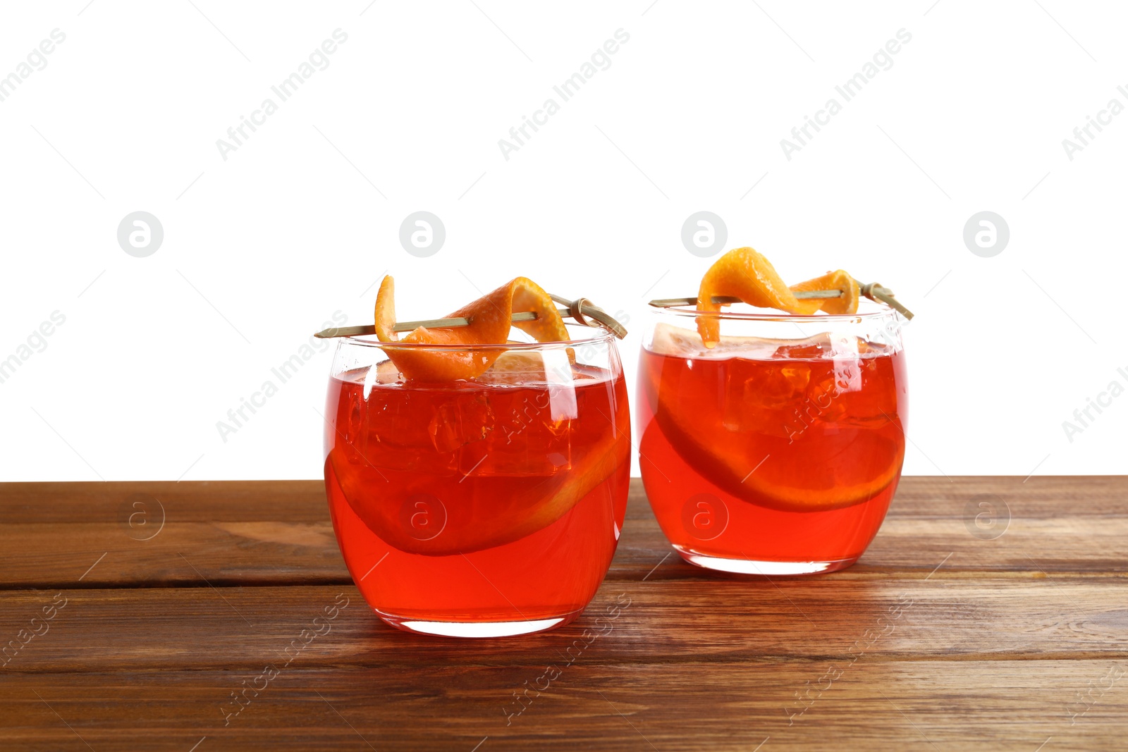 Photo of Aperol spritz cocktail and orange slices in glasses on wooden table against white background