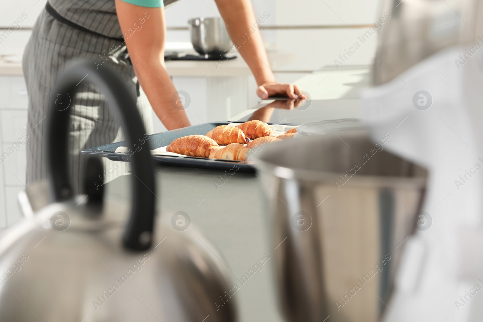 Photo of Oven sheet with freshly baked croissants on kitchen counter
