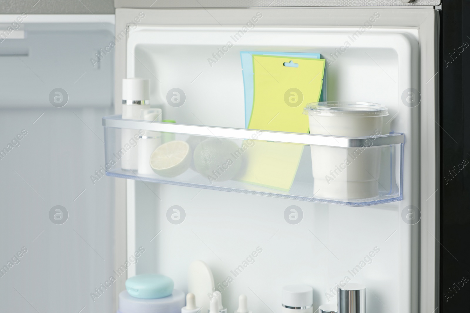 Photo of Different cosmetic products on shelves in refrigerator