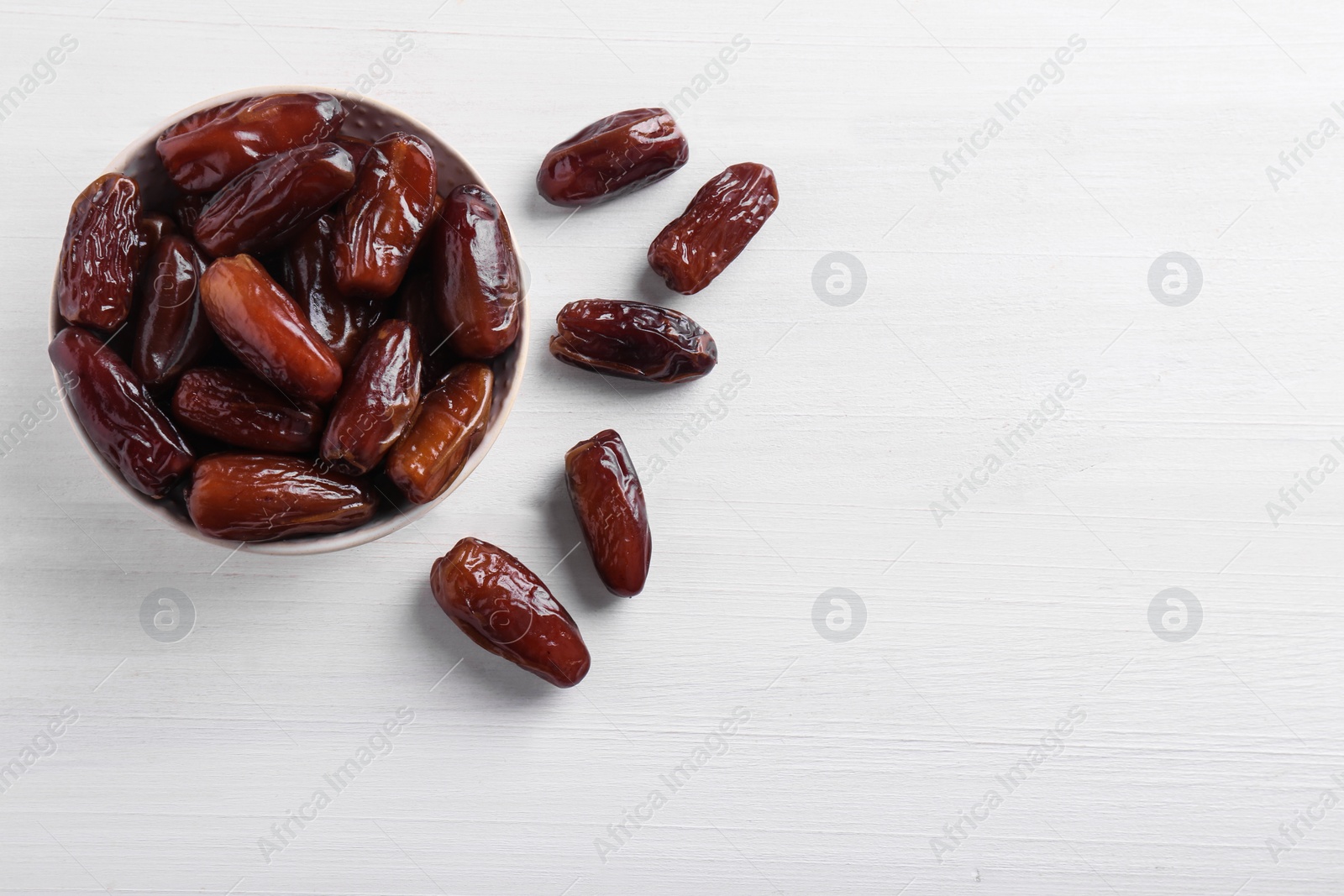 Photo of Sweet dried dates on white wooden background, flat lay. Space for text
