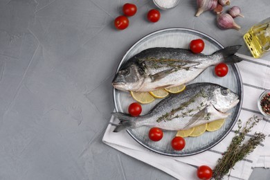 Photo of Flat lay composition with raw dorado fish on grey table. Space for text