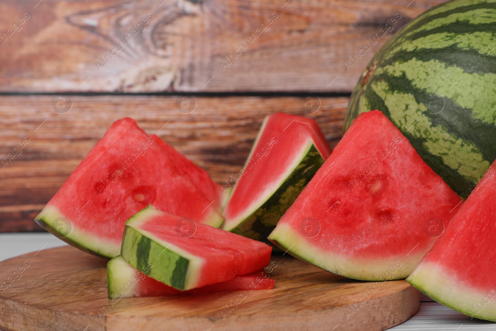 Photo of Juicy ripe cut and whole watermelons on table, closeup