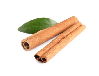 Photo of Cinnamon sticks and green leaf isolated on white
