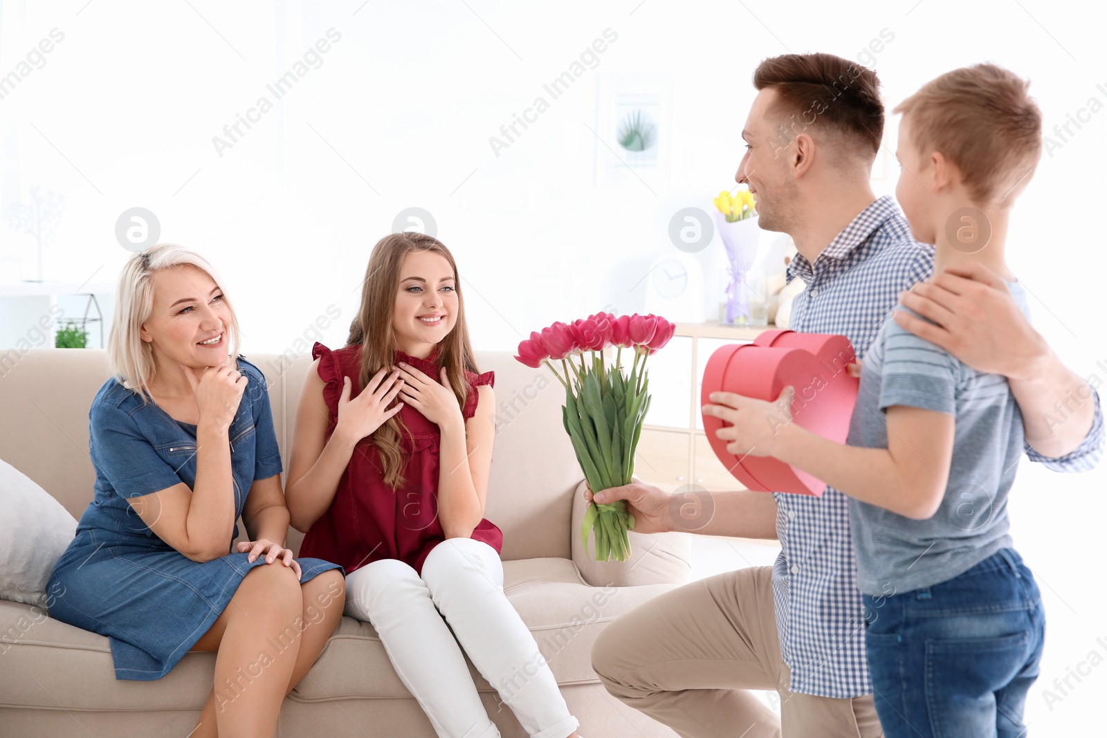 Photo of Man and little boy congratulating women at home