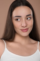 Photo of Portrait of beautiful young woman on brown background