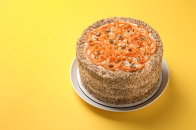 Dish with delicious carrot cake on color background. Space for text