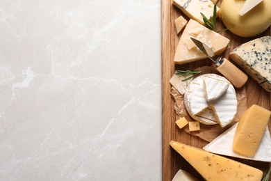 Photo of Different delicious cheeses served on grey table, top view. Space for text