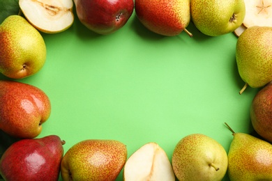 Ripe juicy pears on green background, flat lay. Space for text