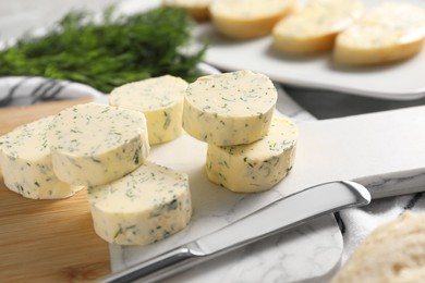 Photo of Tasty butter with dill and knife on table, closeup