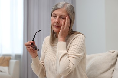 Photo of Overwhelmed woman with glasses suffering at home