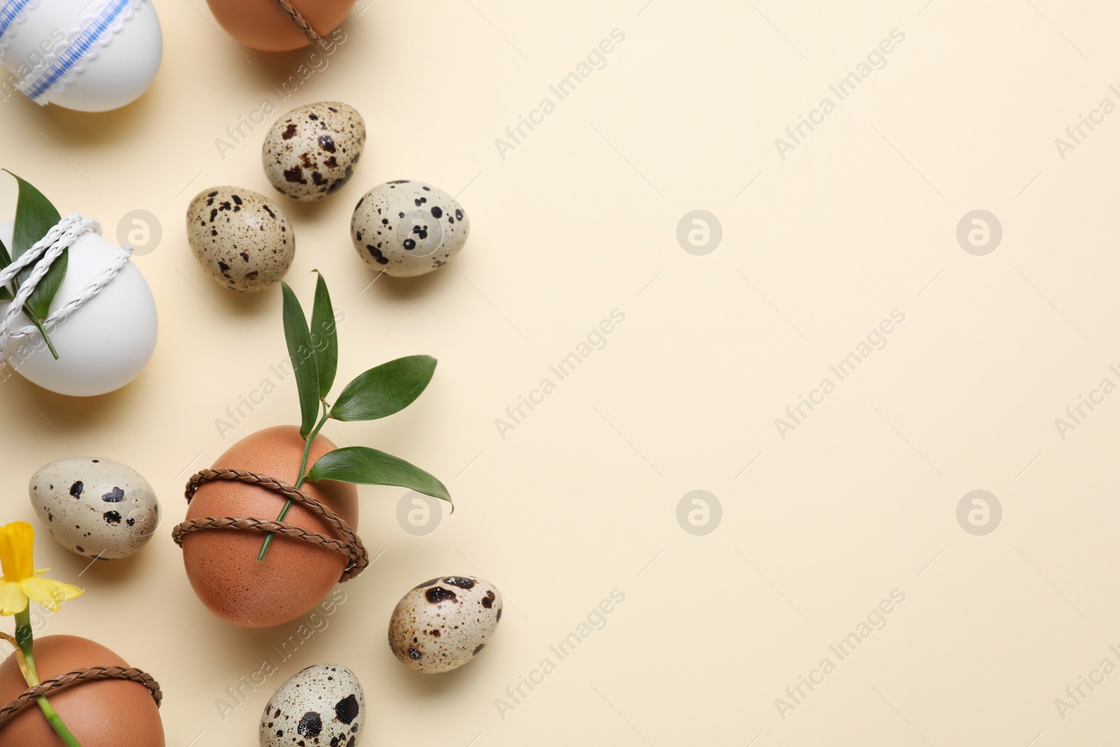 Photo of Festively decorated Easter eggs on beige background, flat lay. Space for text