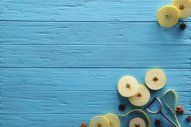 Photo of Food photography. Slices of apple, anise stars, walnuts and peeler on light blue wooden table, flat lay with space for text