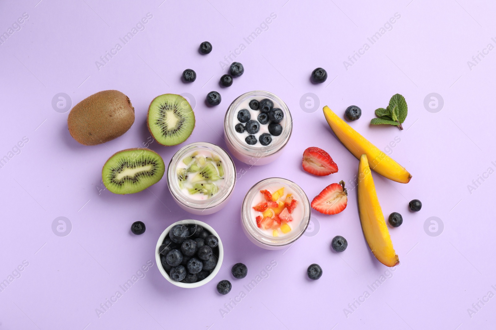 Photo of Jars of fresh yogurt and different fruits on lilac background, flat lay