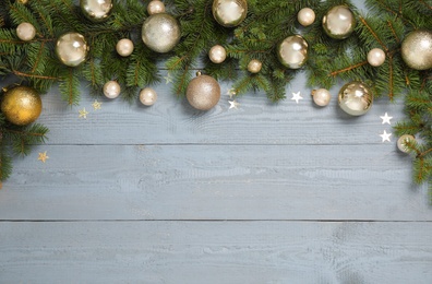 Fir branches with Christmas decoration on grey wooden background, flat lay. Space for text