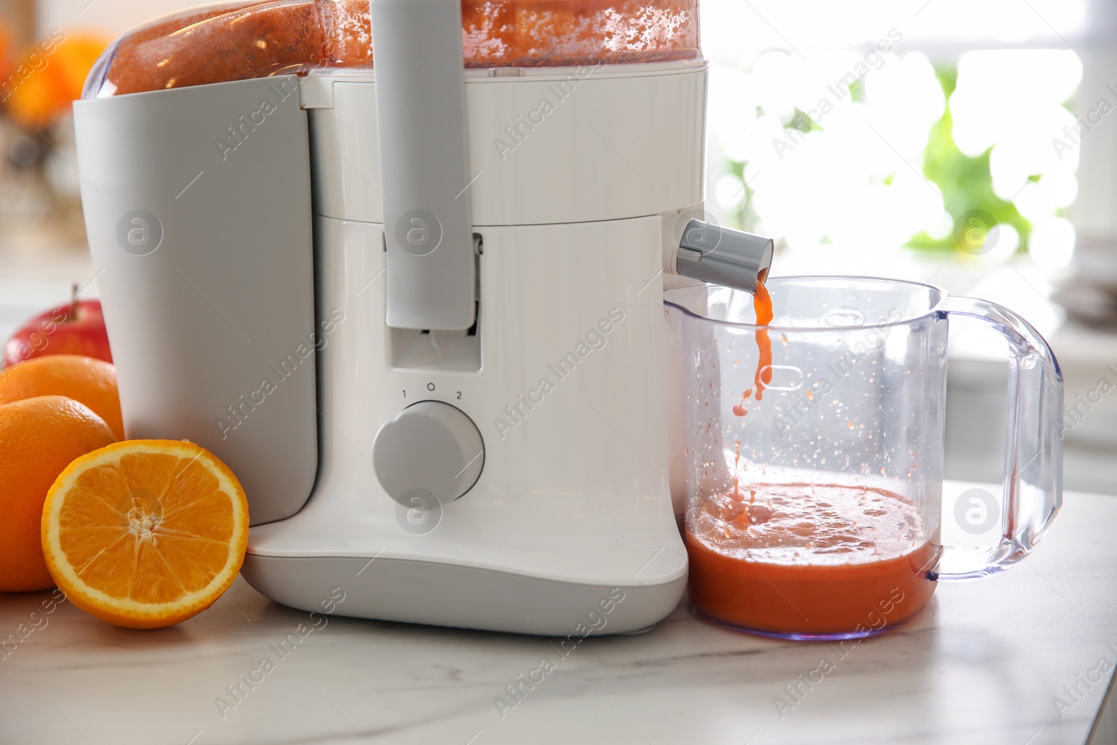 Photo of Modern juicer and fresh oranges on table in kitchen, closeup