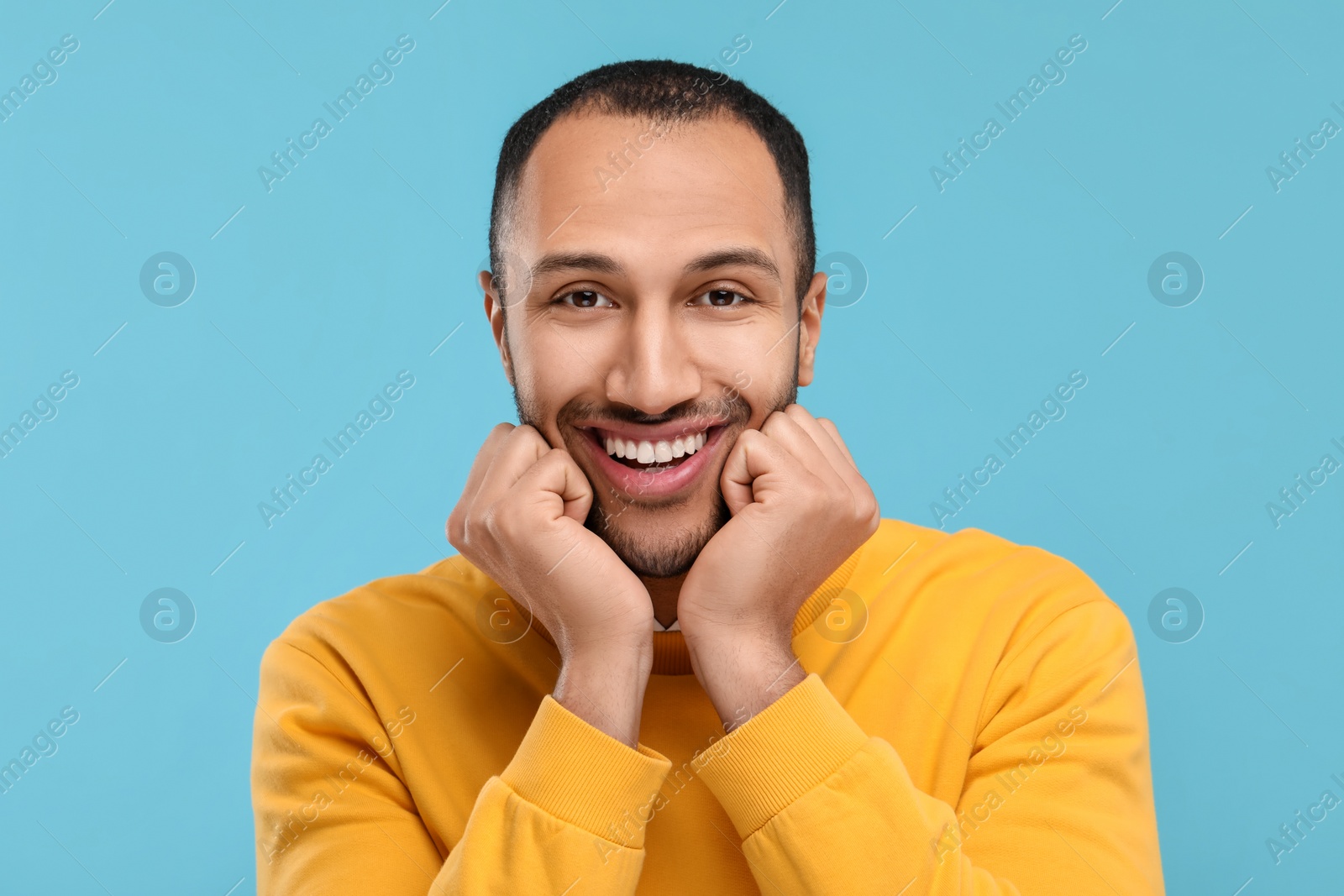 Photo of Portrait of smiling man with healthy clean teeth on light blue background