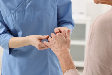 Photo of Arthritis symptoms. Doctor examining patient's hand in hospital, closeup