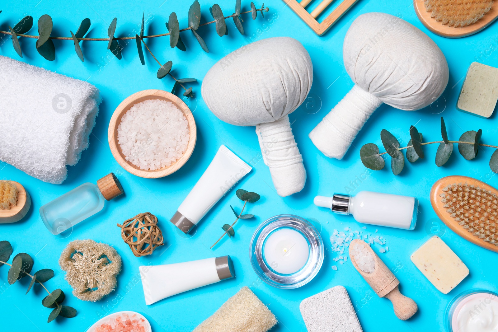 Photo of Flat lay composition with spa products and eucalyptus branches on light blue background