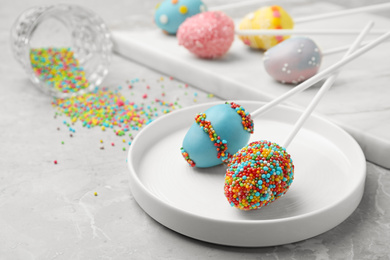 Photo of Egg shaped cake pops for Easter celebration on grey marble table