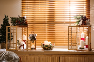 Photo of Beautiful Christmas lanterns on windowsill in decorated room