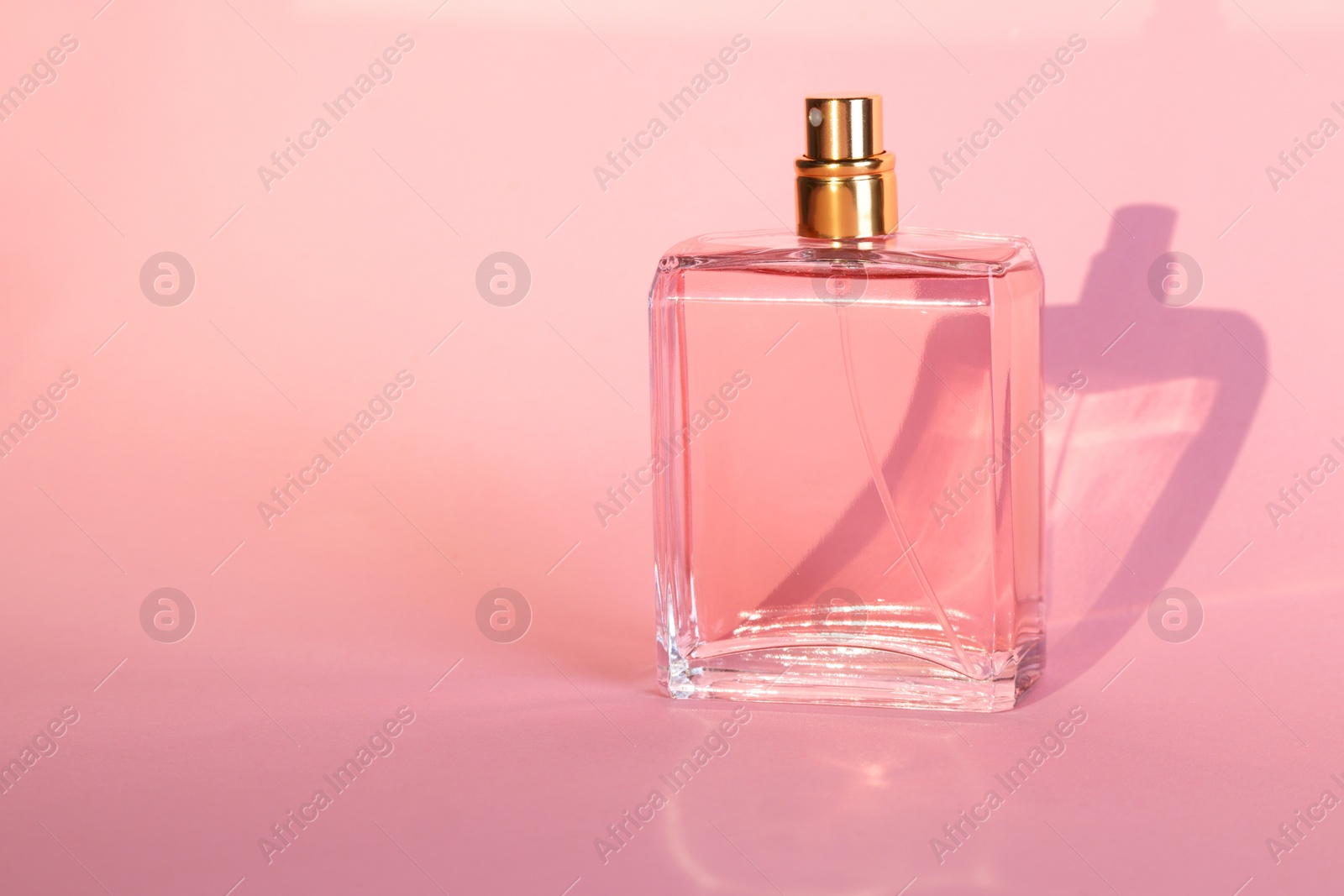 Photo of Luxury women's perfume in bottle on violet background. Space for text