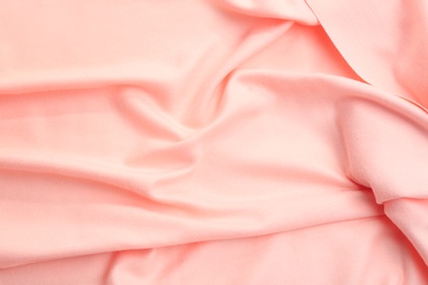 Photo of Elegant peach cloth as background, closeup view