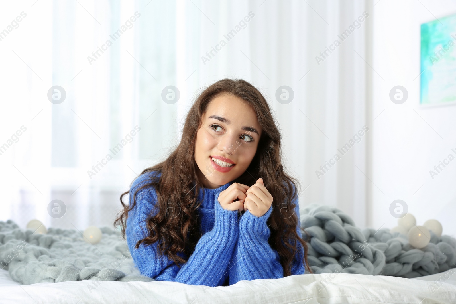 Photo of Portrait of young beautiful woman lying on bed at home