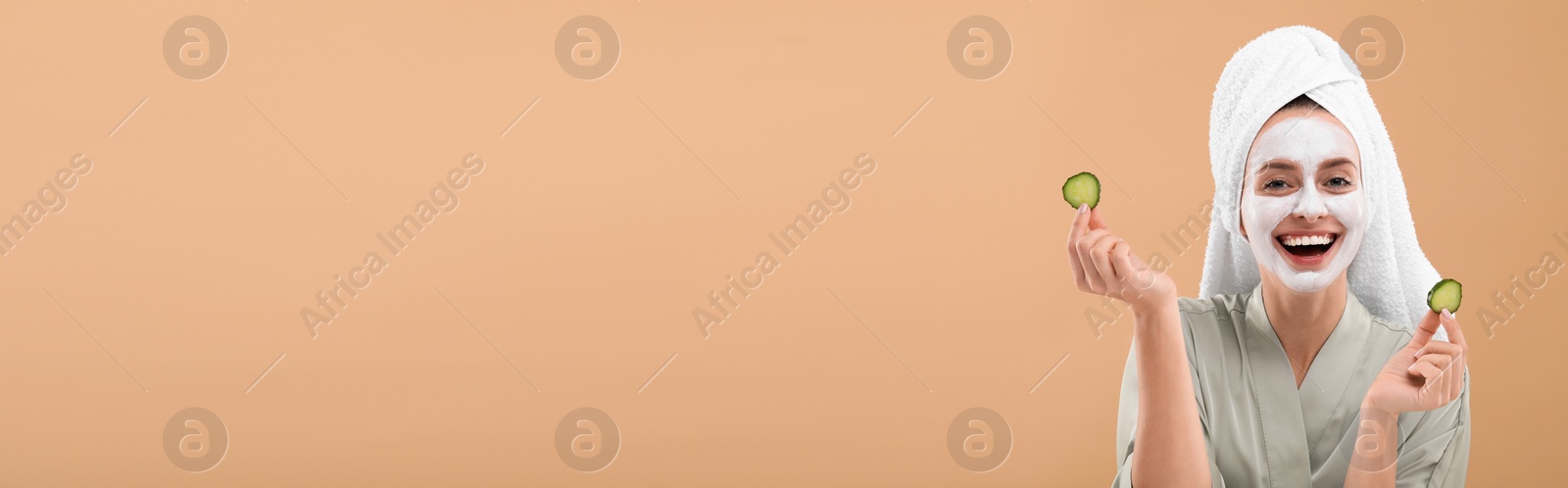 Image of Spa treatment. Happy woman with face mask and cucumber slices on pale orange background. Banner design with space for text