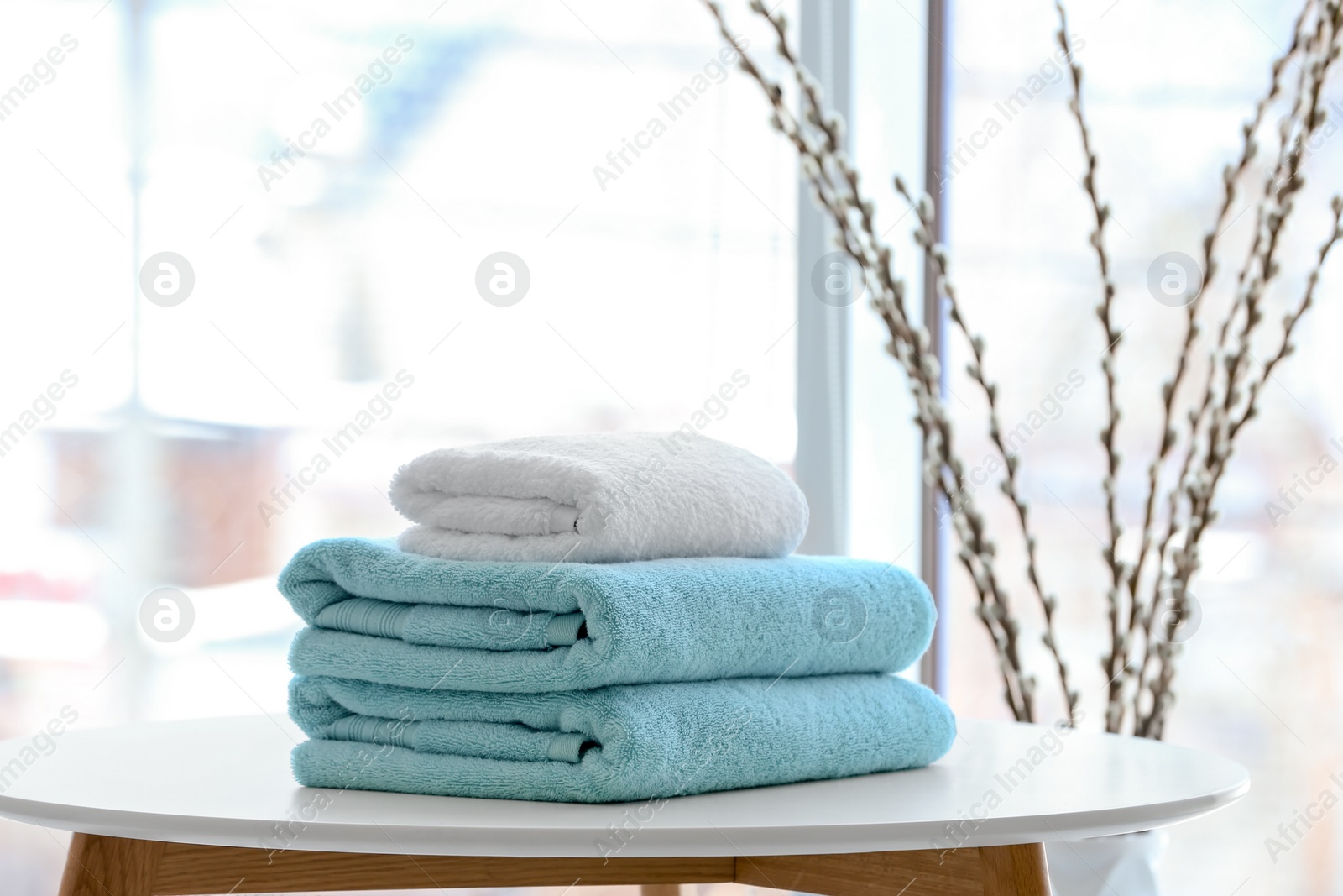 Photo of Stack of towels on table against blurred background