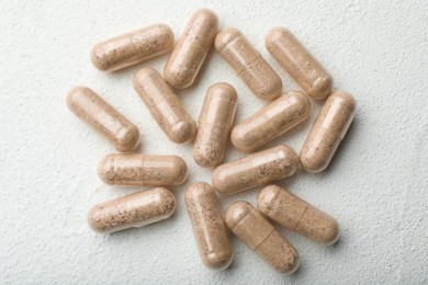 Gelatin capsules on white table, flat lay