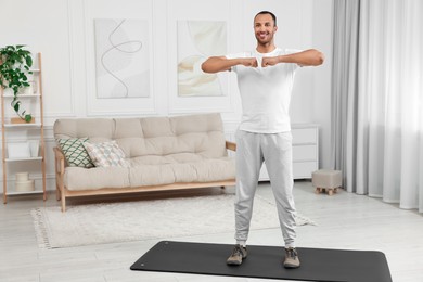 Photo of Man doing morning exercise on fitness mat at home