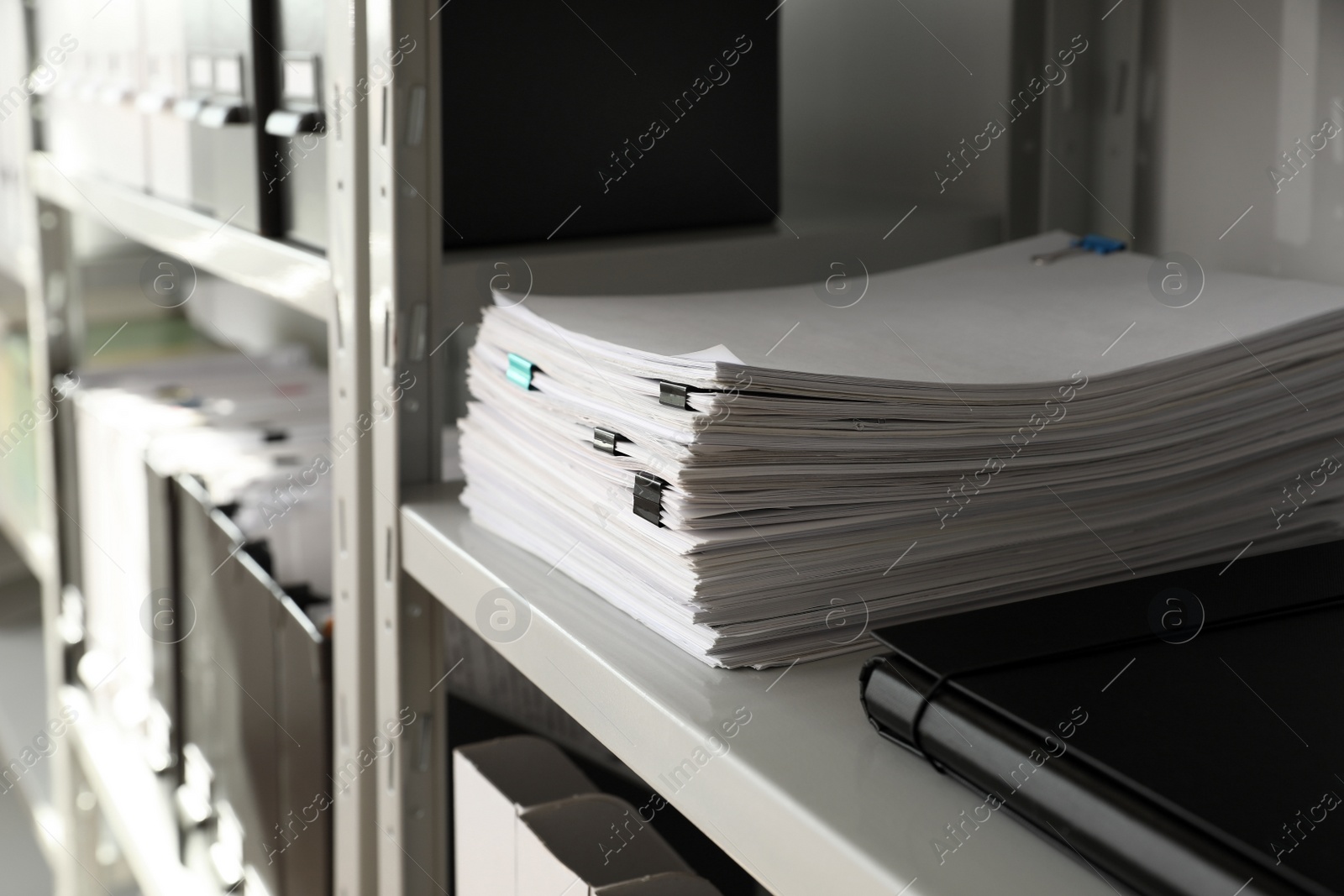 Photo of Stack of documents with paper clips on shelf in office