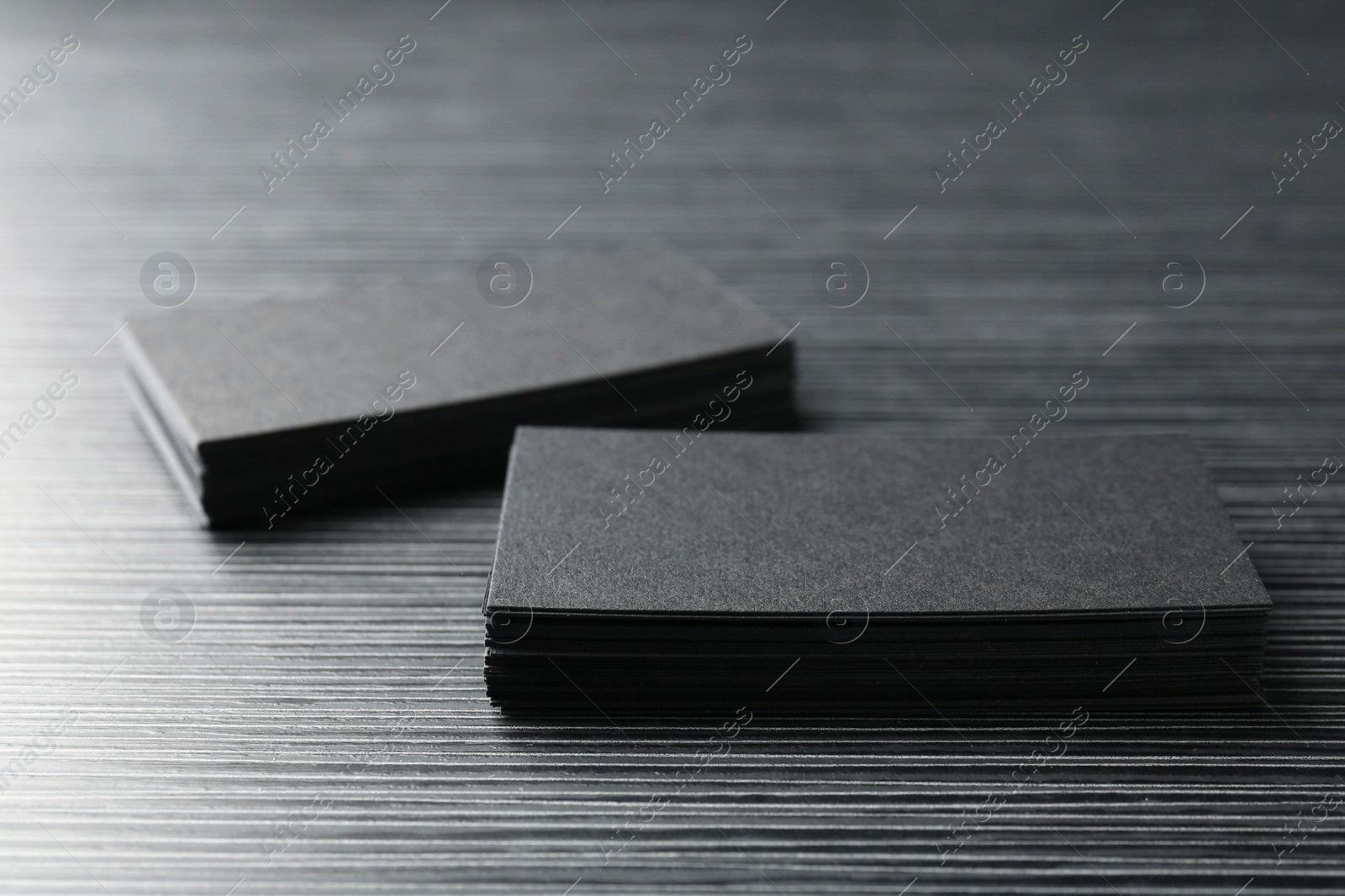 Photo of Blank black business cards on wooden table, closeup. Mockup for design