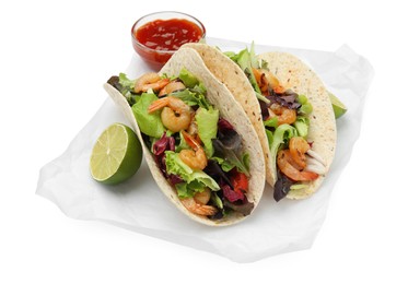 Delicious tacos with shrimps, lime and sauce on white background