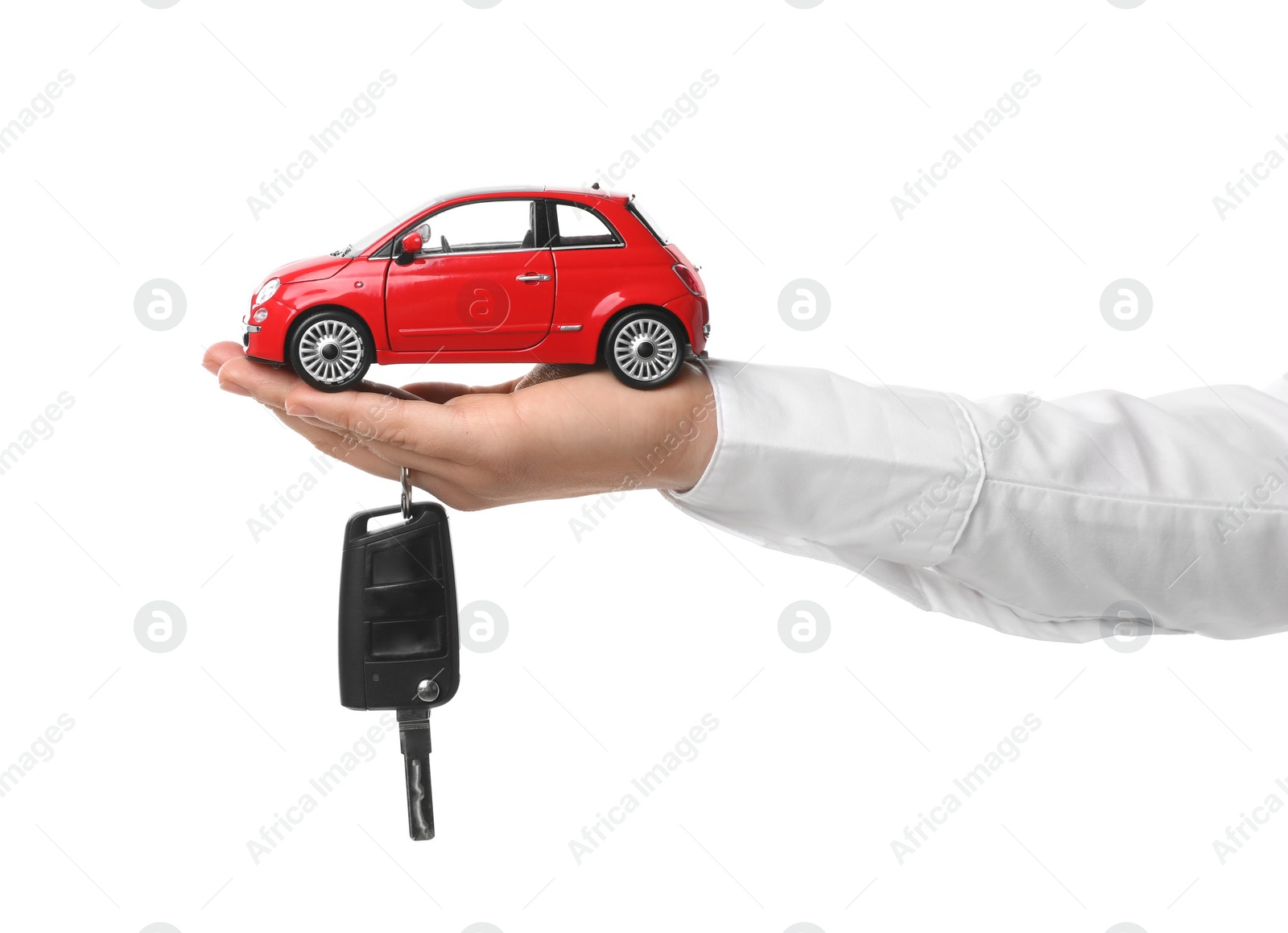 Photo of Man holding key and miniature automobile model on white background, closeup. Car buying