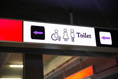 Image of Public toilet sign with symbols and arrow showing direction