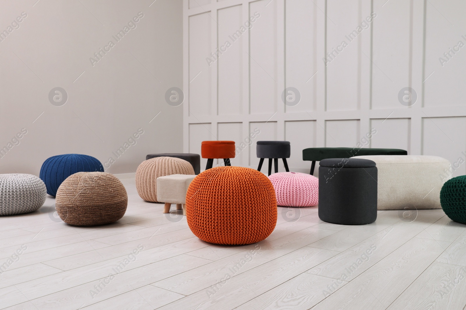 Photo of Different stylish poufs and ottomans in room