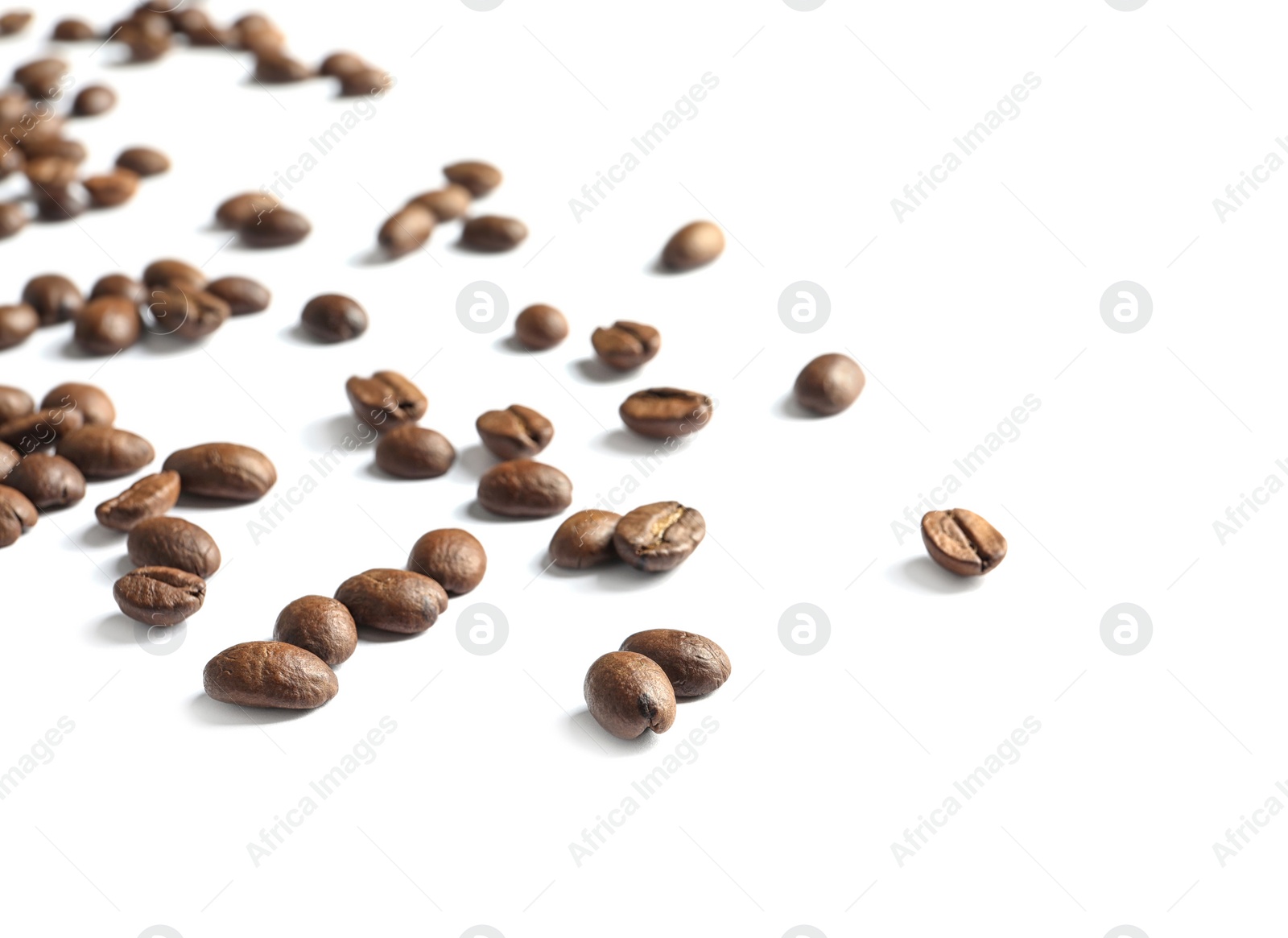 Photo of Scattered roasted coffee beans on white background