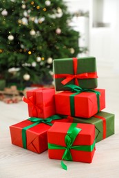 Photo of Beautifully wrapped Christmas gifts on wooden table indoors