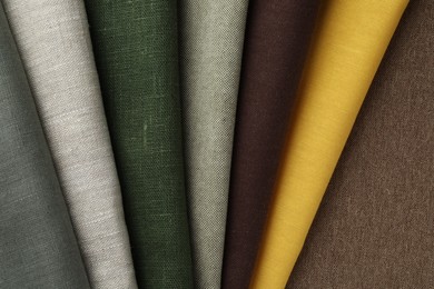 Photo of Many different fabrics on brown cloth, top view