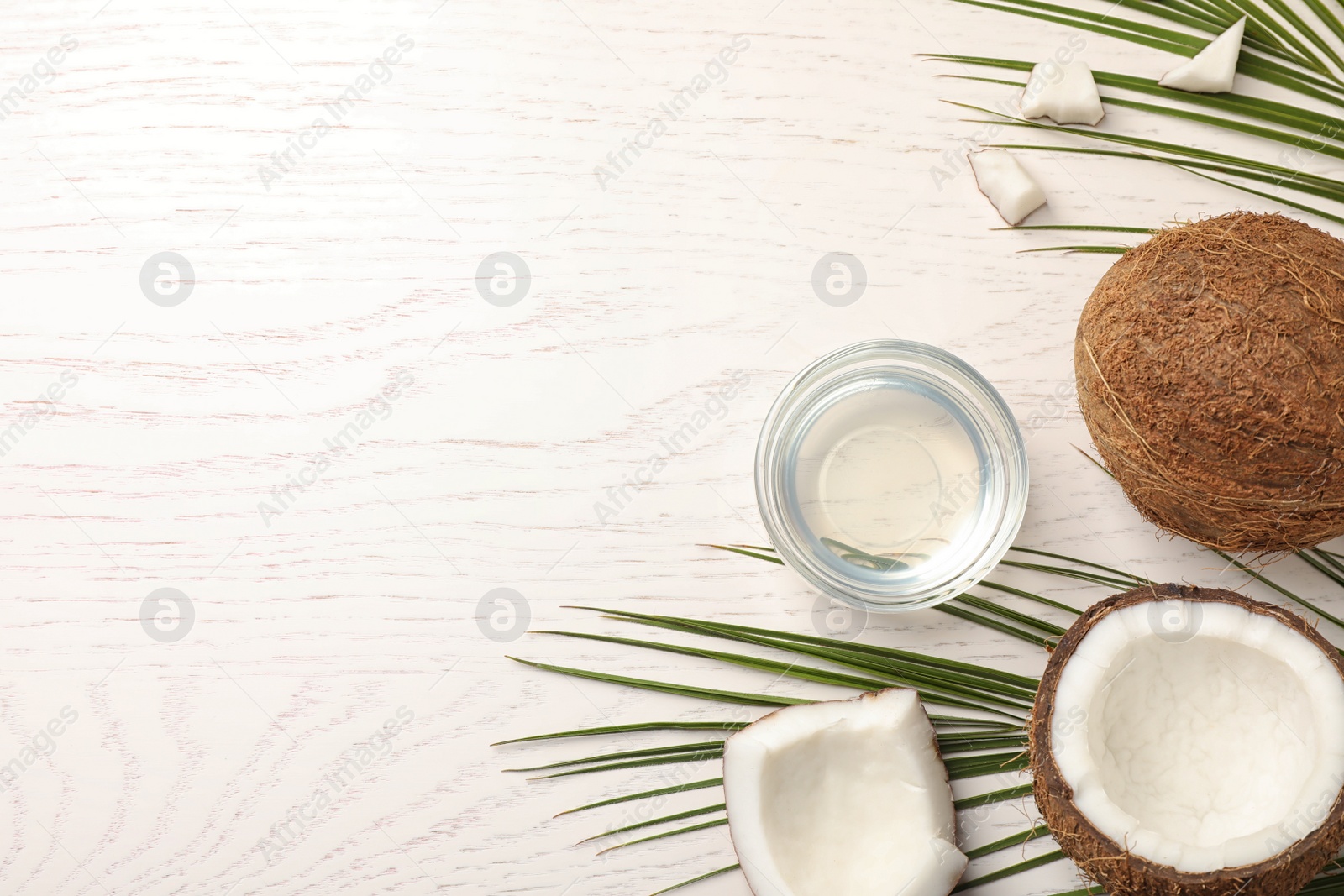 Photo of Flat lay composition with coconut oil on white wooden table, space for text