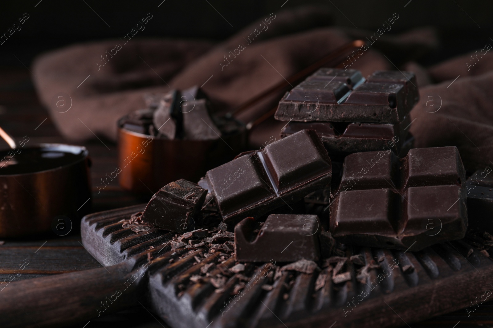 Photo of Delicious dark chocolate on wooden board, closeup