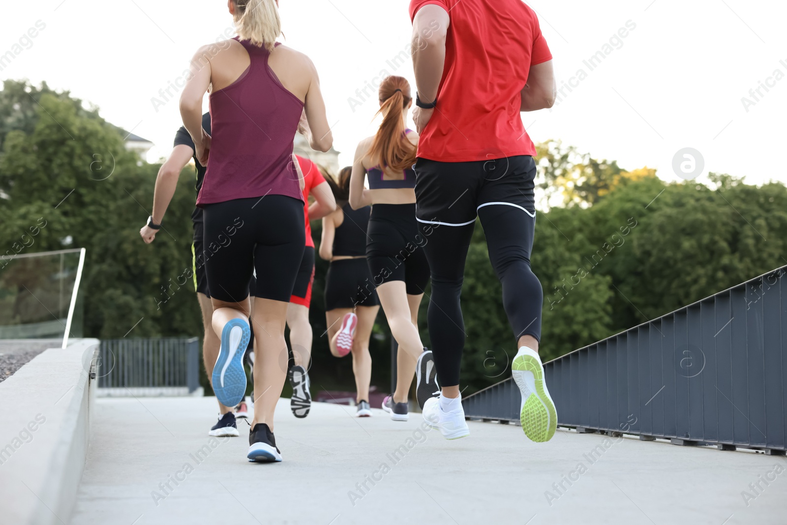 Photo of Group of people running outdoors, back view