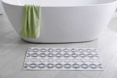 Stylish mat on floor near tub in bathroom. Interior design