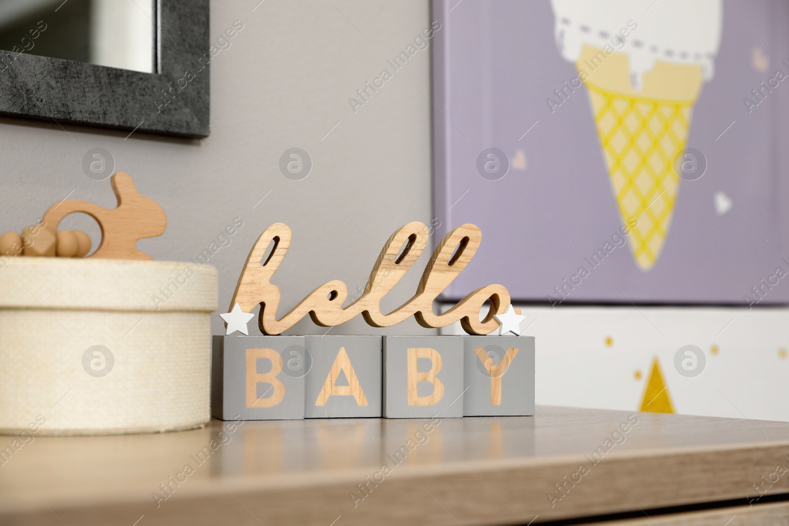 Photo of Decorative phrase HELLO BABY on table in baby room. Interior design